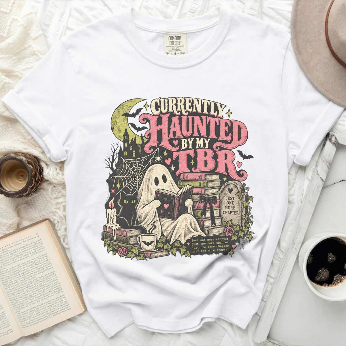 White t-shirt with ghost reading book, black cat, bats, and "Currently Haunted By My TBR" text.