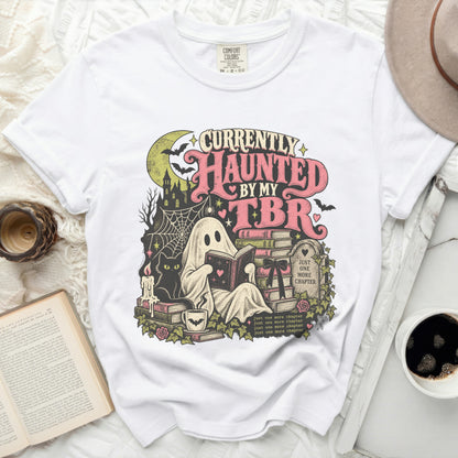 White t-shirt with ghost reading book, black cat, bats, and "Currently Haunted By My TBR" text.