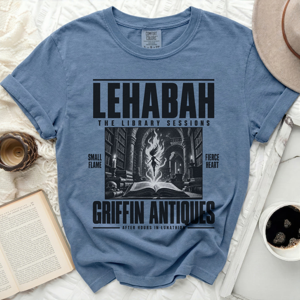 Blue t-shirt with "LEHABAH THE LIBRARY SESSIONS GRIFFIN ANTIQUES" text and illustration.