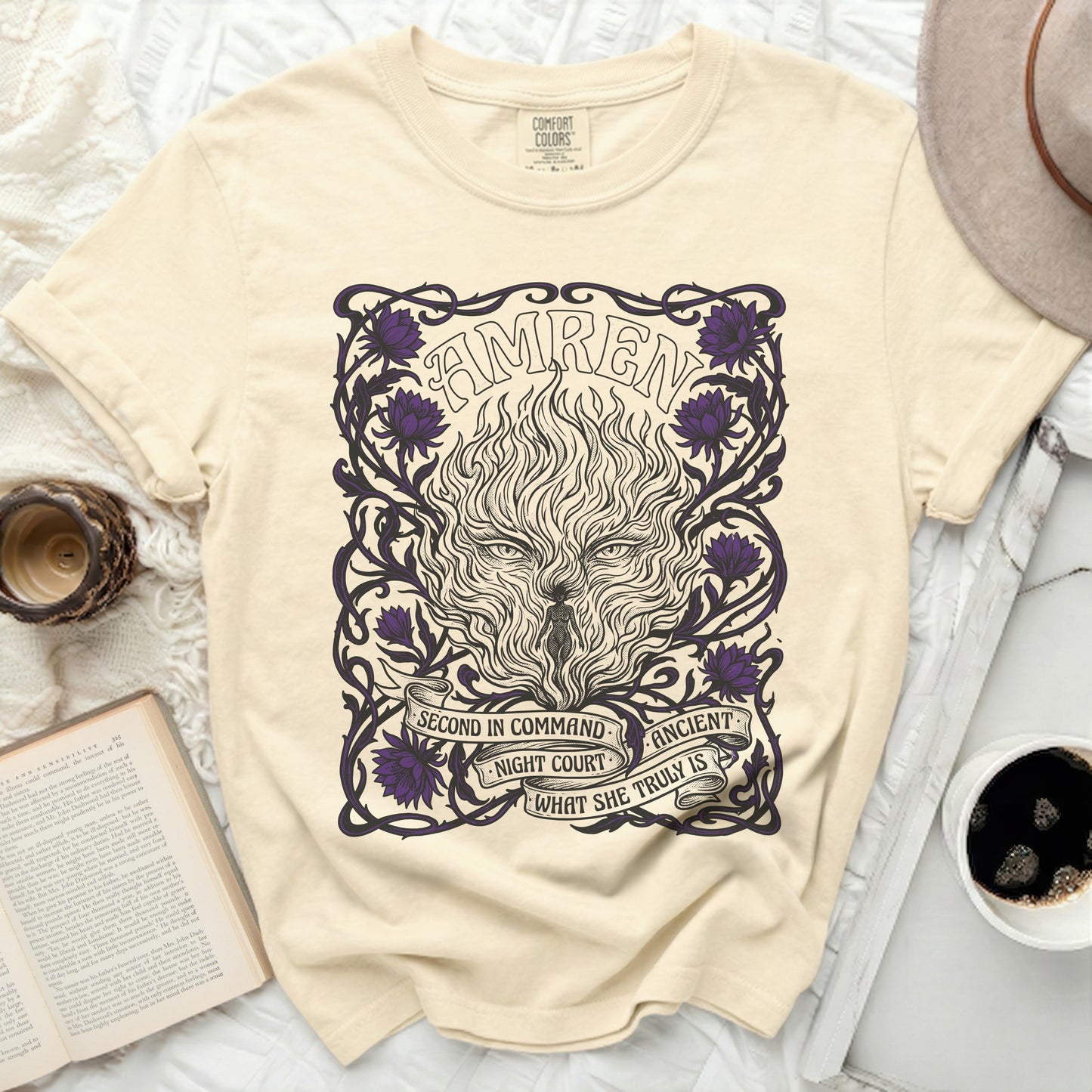 Cream t-shirt with "AMREN" and wolf-like fire design, flowers, and text.