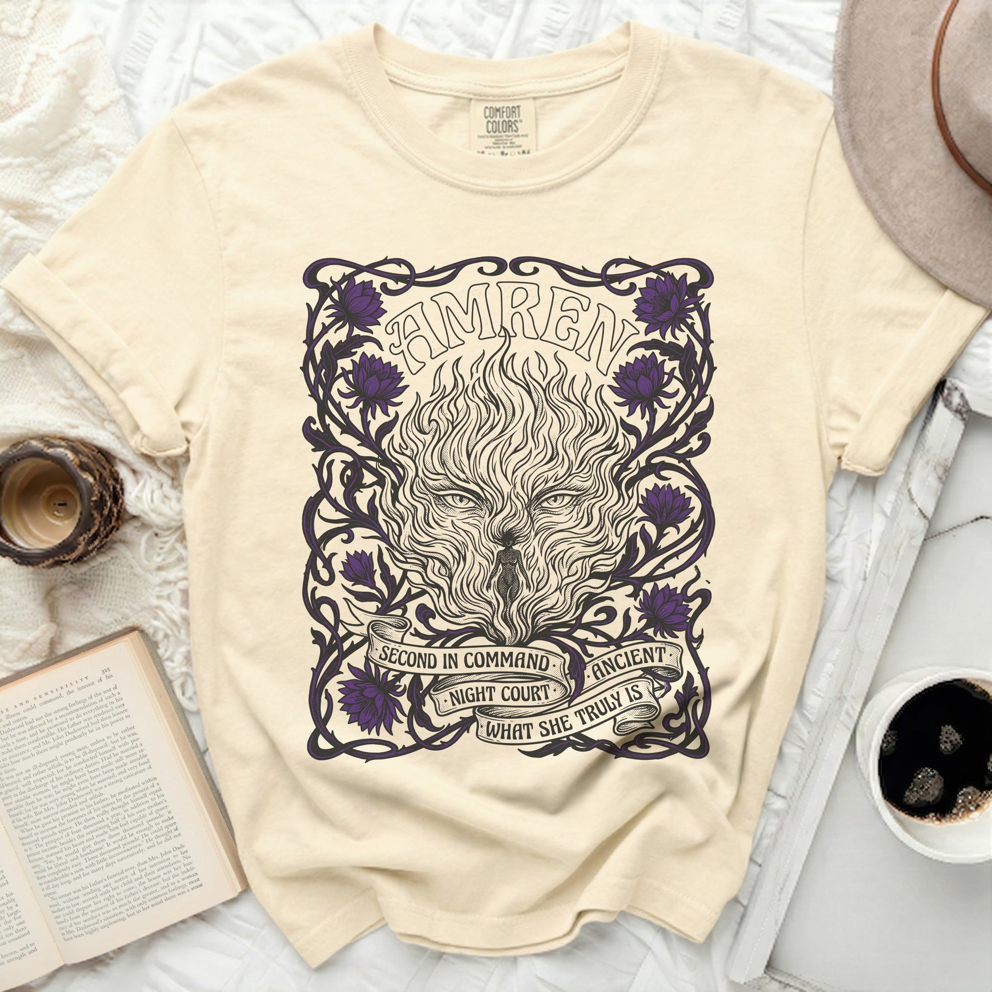 Cream t-shirt with "AMREN" and wolf-like fire design, flowers, and text.