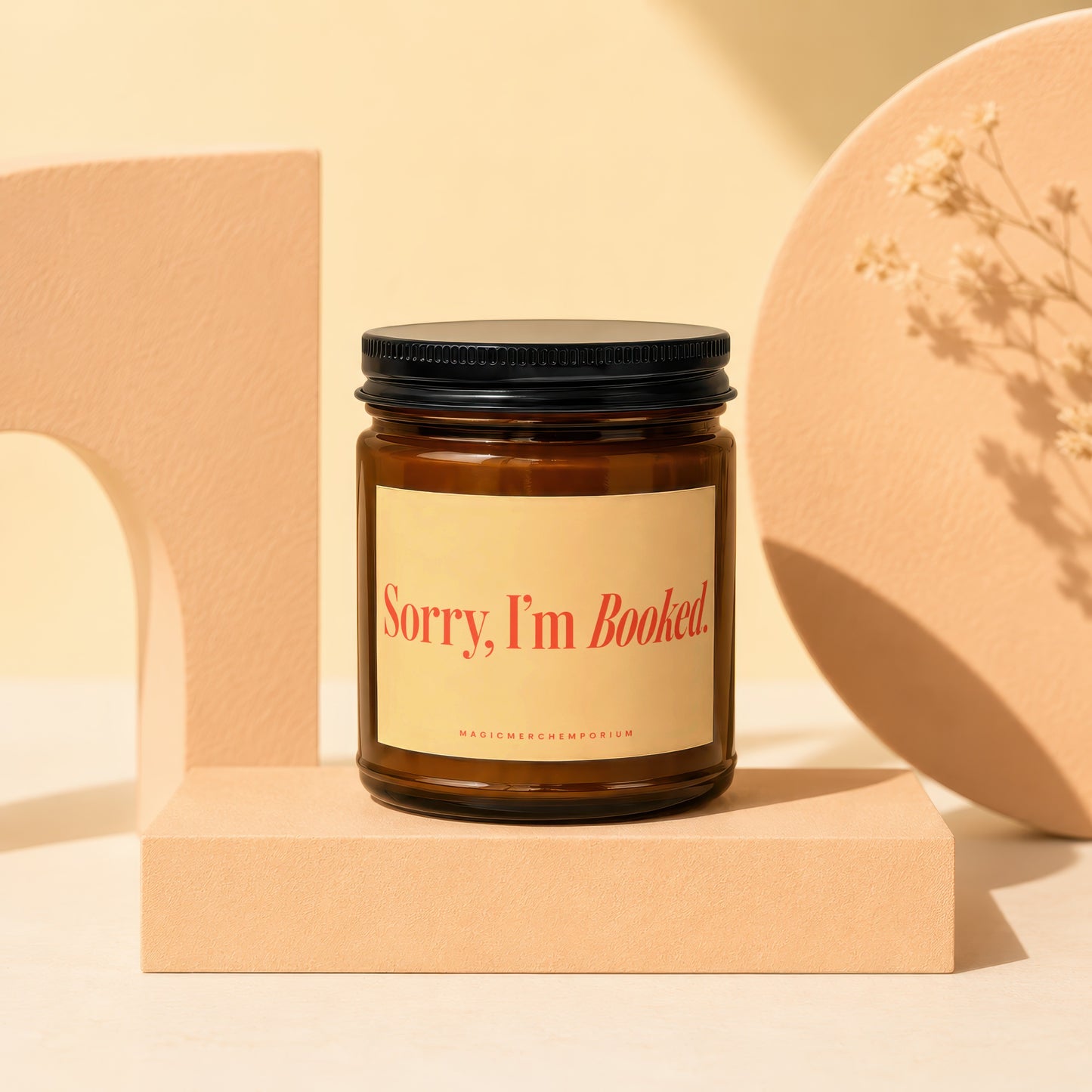 Amber jar candle with black lid and "Sorry, I'm Booked" label.