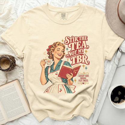 Woman winks holding tea, reading book with text "Stir the tea, not my TBR".