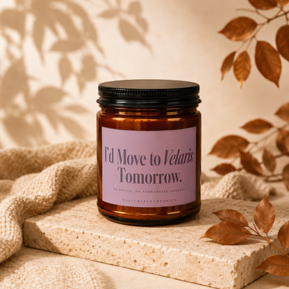 Amber glass candle jar with a black lid and purple label on a stone slab.