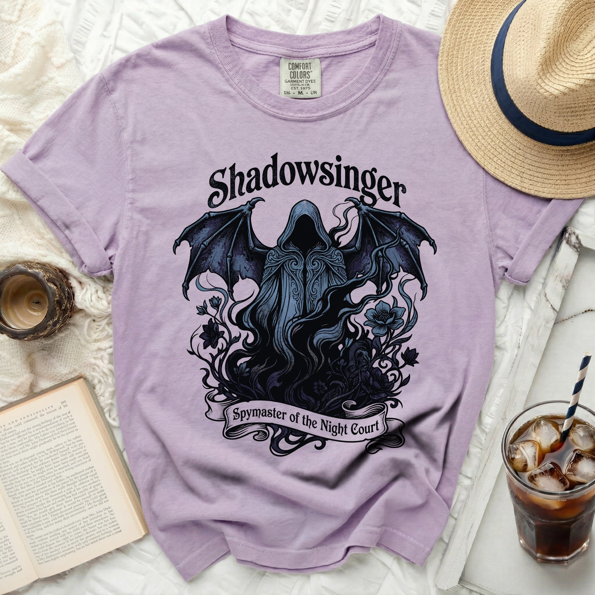 Purple t-shirt with a dark graphic of a winged hooded figure and the text "Shadowsinger Spymaster of the Night Court".