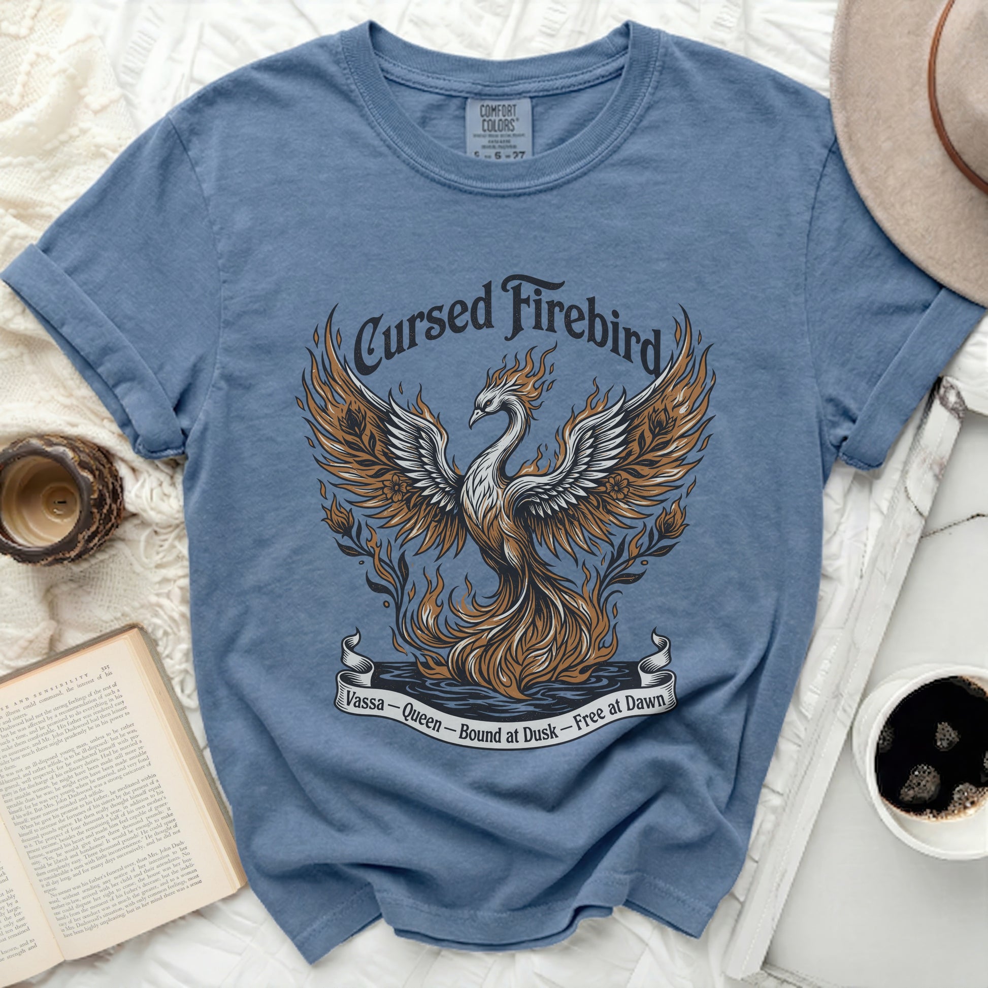 Blue t-shirt with a graphic of a fiery phoenix and text "Cursed Firebird Vassa - Queen - Bound at Dusk - Free at Dawn".