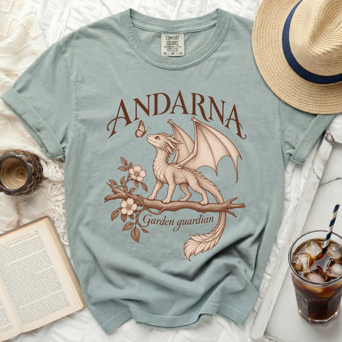 Pale blue t-shirt with "ANDARNA Garden guardian" text and dragon illustration.