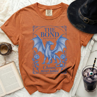 Burnt orange crewneck t-shirt featuring a blue graphic of a dragon and the text The Bond Basgiath Chosen, never tamed.