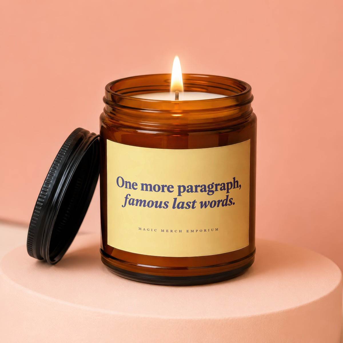 Amber jar candle with lit wick, reads "One more paragraph, famous last words."