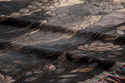 a close-up view of a textured fabric with a floral pattern. The fabric appears to be a woven or knitted material, with a dark background and a lighter, more intricate floral design in the center.
