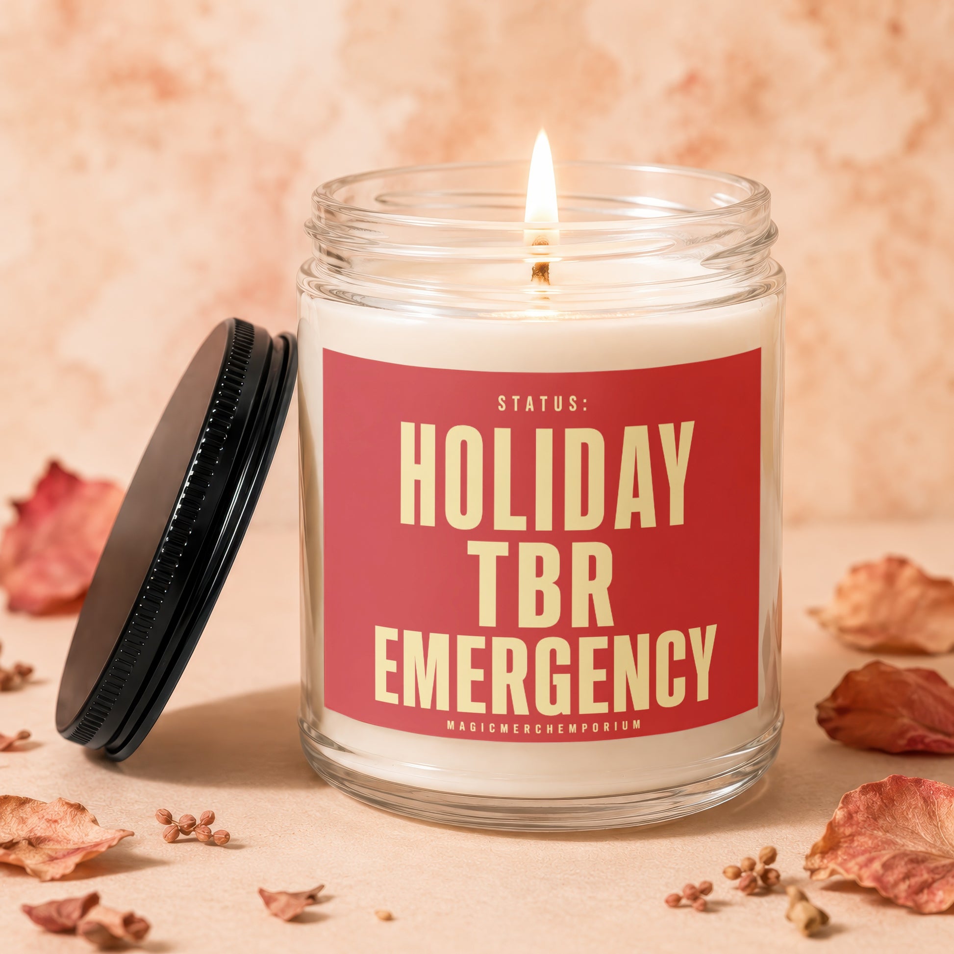 Lit candle in glass jar with red label that says "STATUS: HOLIDAY TBR EMERGENCY"