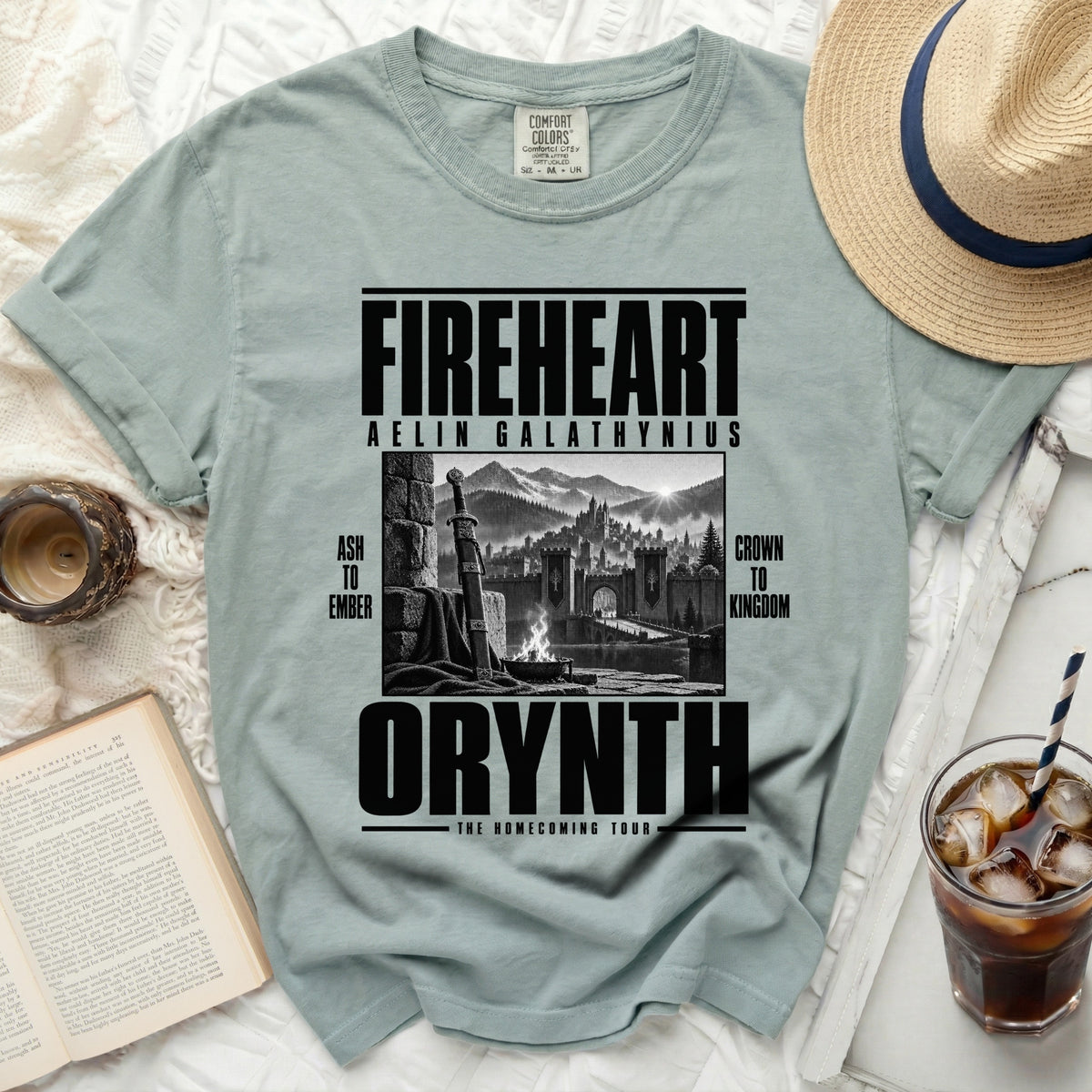Light blue t-shirt with "Fireheart Aelin Galathynius Orynth The Homecoming Tour" graphic.