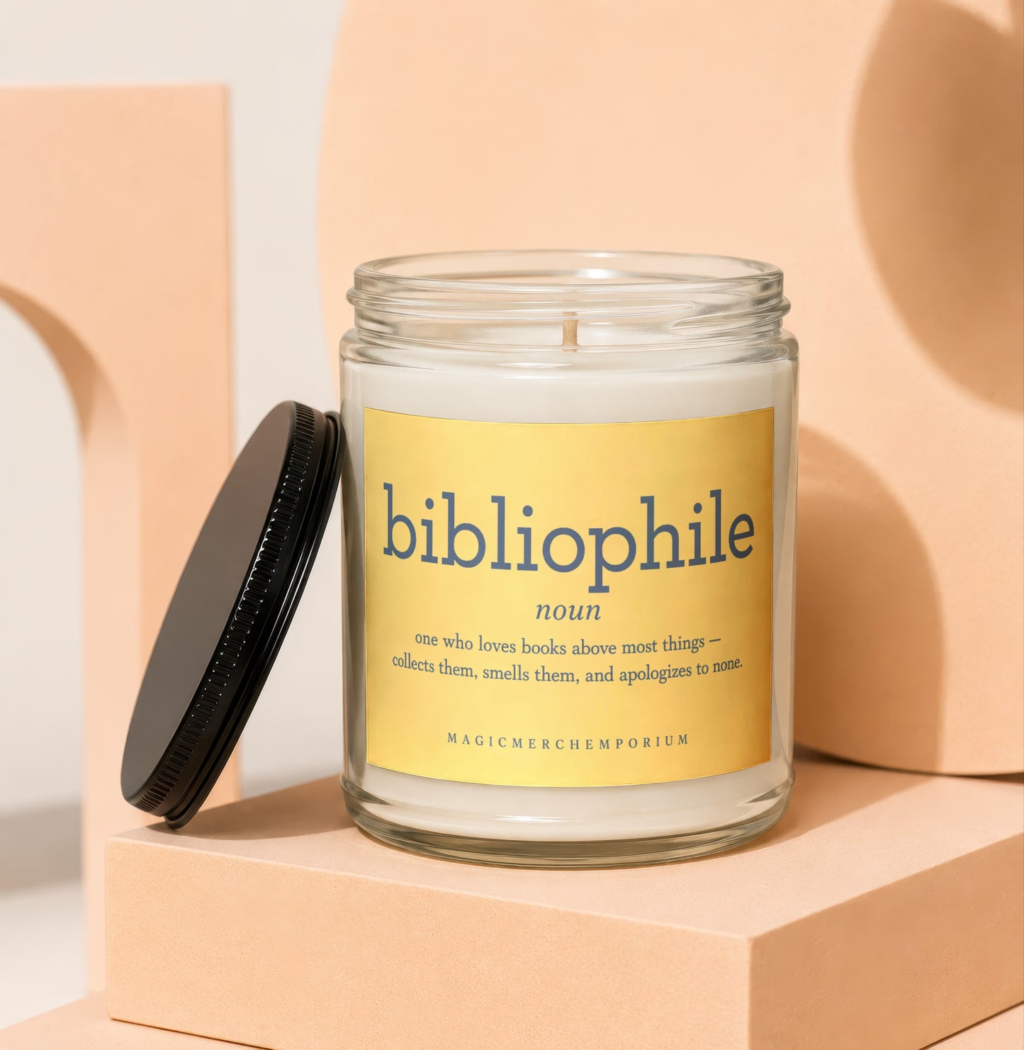 Bibliophile candle in glass jar with yellow label defining bibliophile.