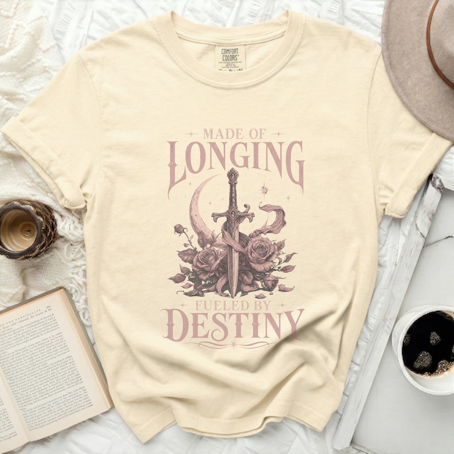 Cream t-shirt with sword, moon, and roses graphic and text "MADE OF LONGING FUELED BY DESTINY".