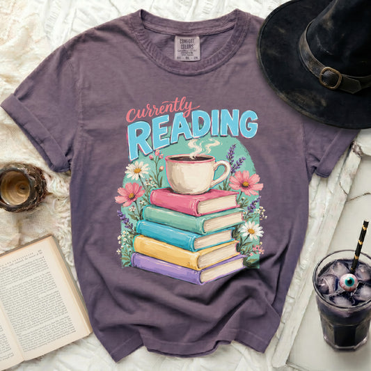 Purple t-shirt with "Currently Reading" text and stack of books.