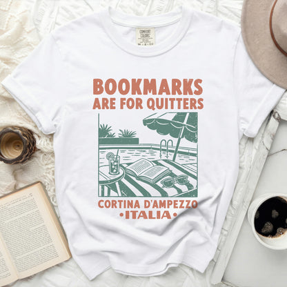 White t-shirt with "Bookmarks are for quitters" and Cortina d'Ampezzo, Italia graphic.