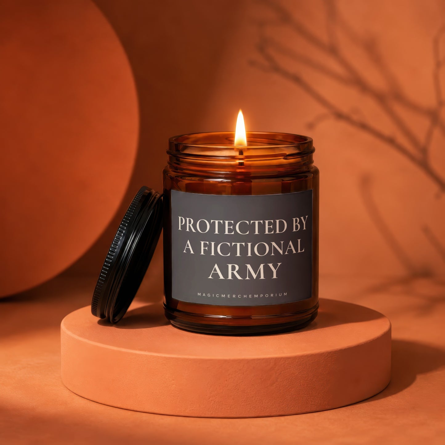 Amber jar candle with lit flame and label saying "PROTECTED BY A FICTIONAL ARMY".