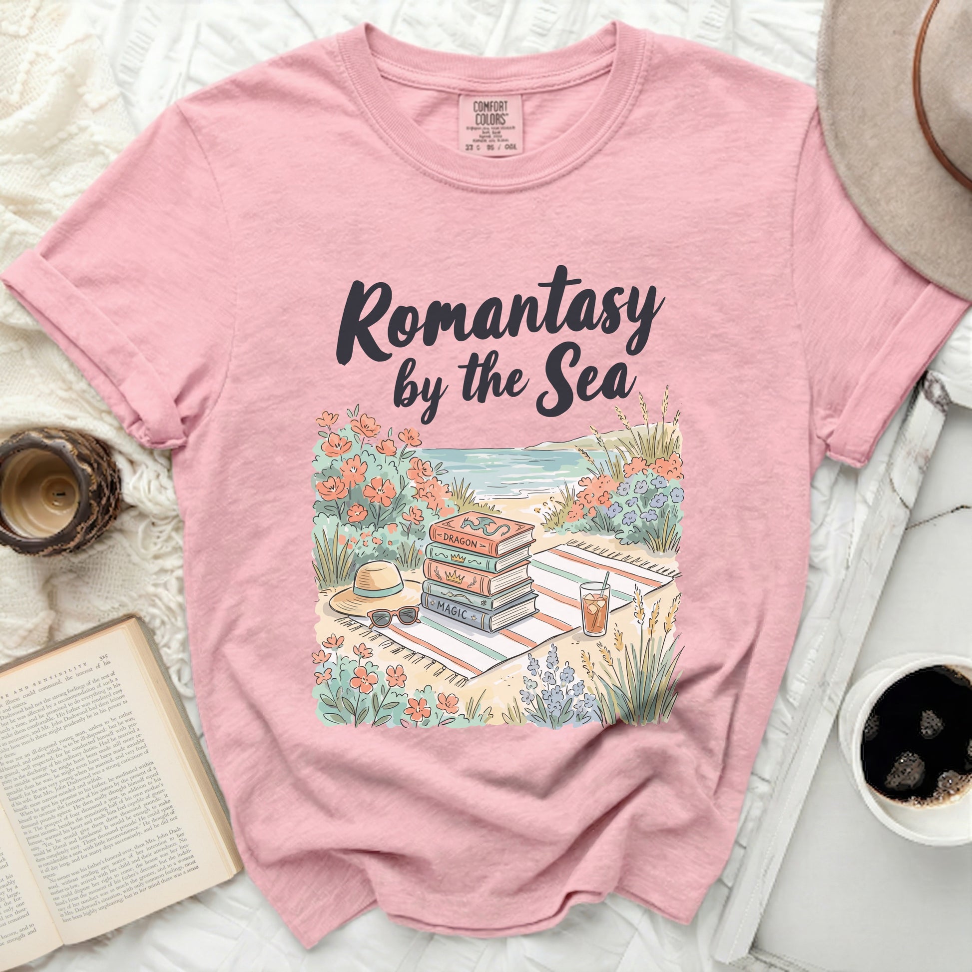 Pink t-shirt with "Romantasy by the Sea" text and stacked books.