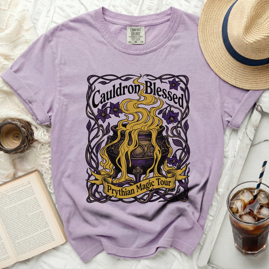 Purple t-shirt with "Cauldron Blessed Prythian Magic Tour" graphic.