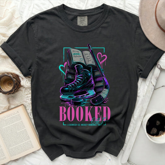 T-shirt with books, ice skate, hockey stick, and "BOOKED" text.