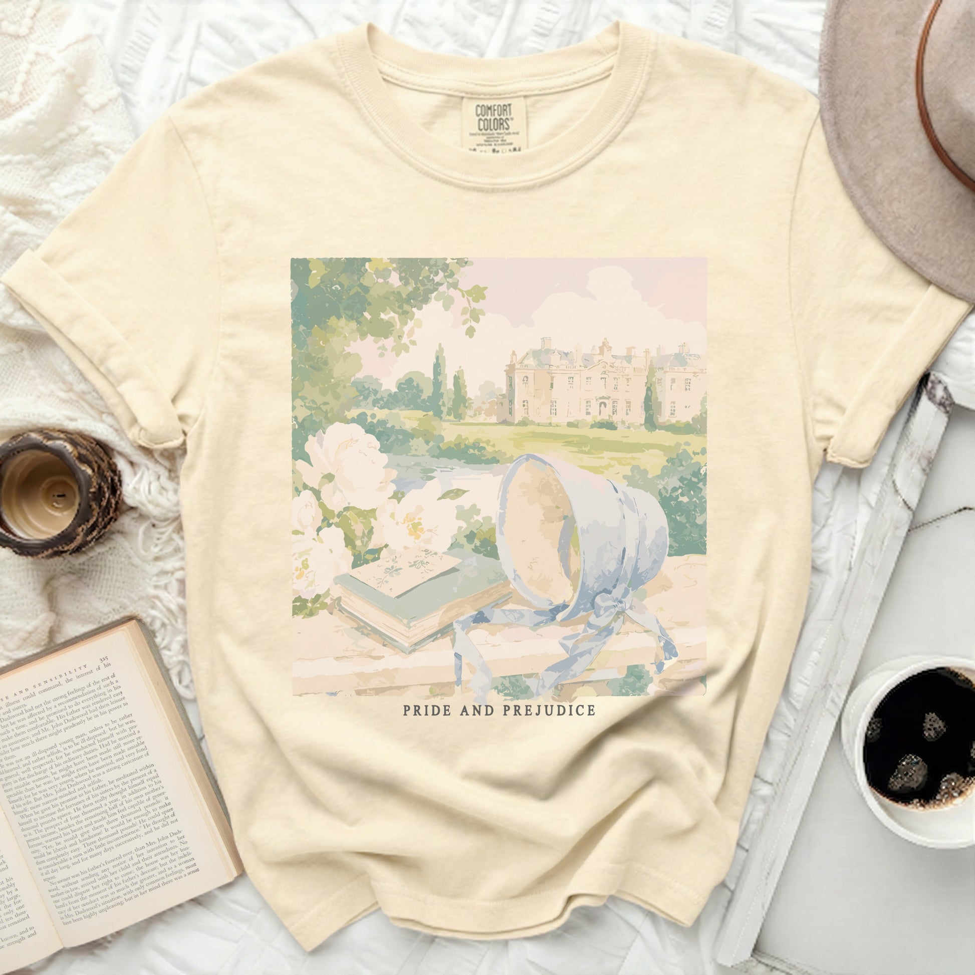 Cream t-shirt with "Pride and Prejudice" print of a manor and garden scene.