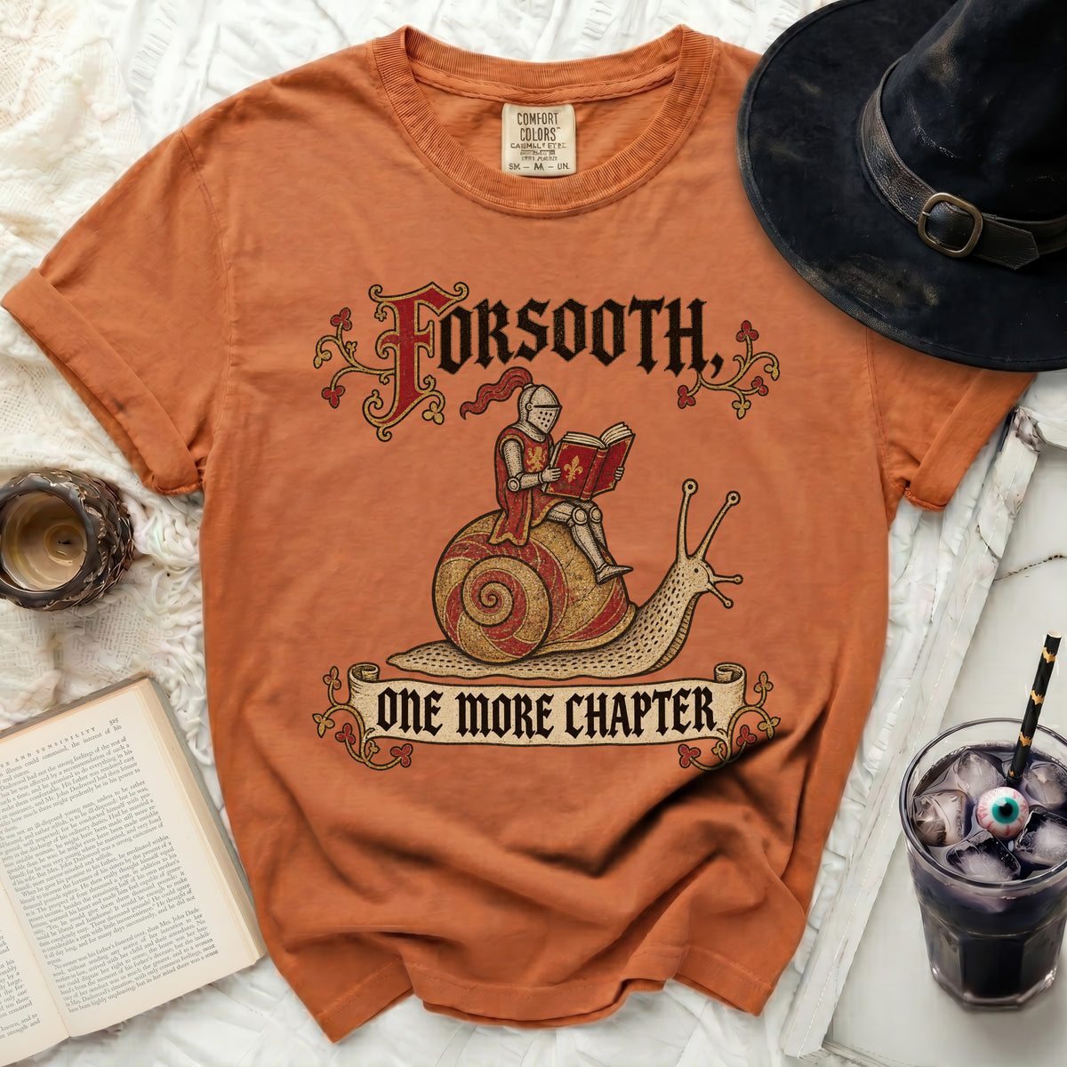 Orange t-shirt with knight on snail graphic and text "FORSOOTH, ONE MORE CHAPTER".