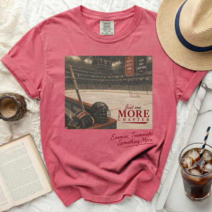 T-shirt with hockey rink graphic, puck, stick, and helmet, text "Just One More Chapter".