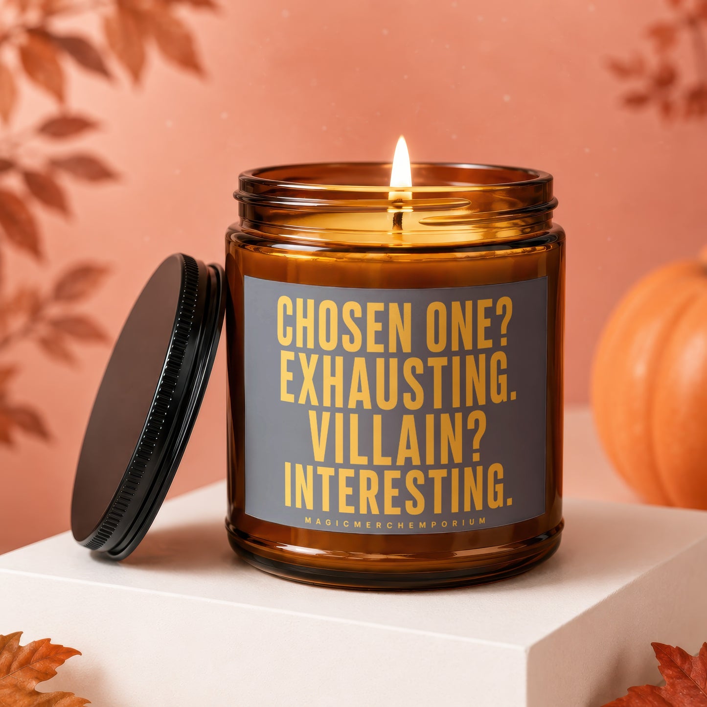 Candle with text "Chosen One? Exhausting. Villain? Interesting." on amber jar, lid off.