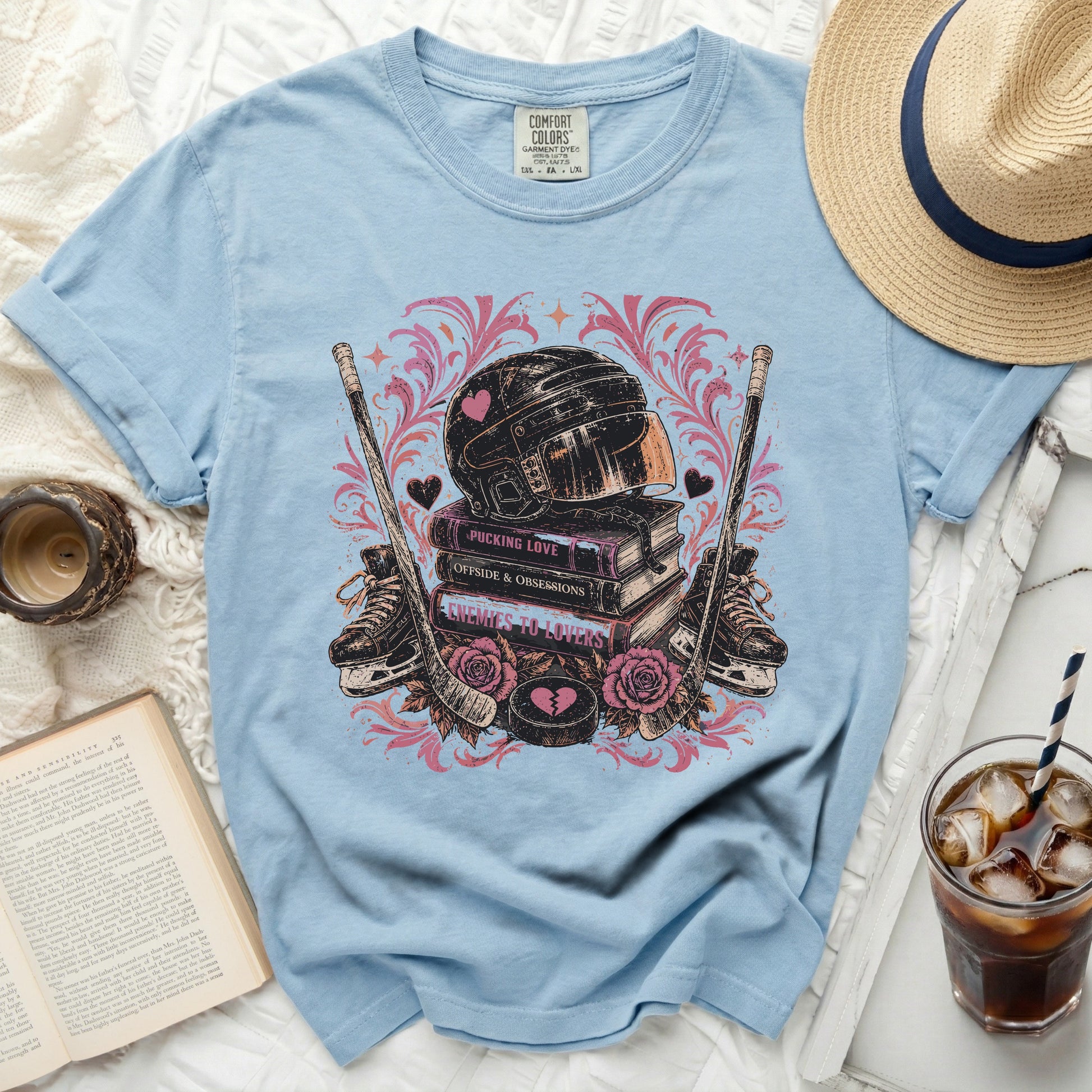 Light blue t-shirt with hockey helmet, skates, and books graphic.