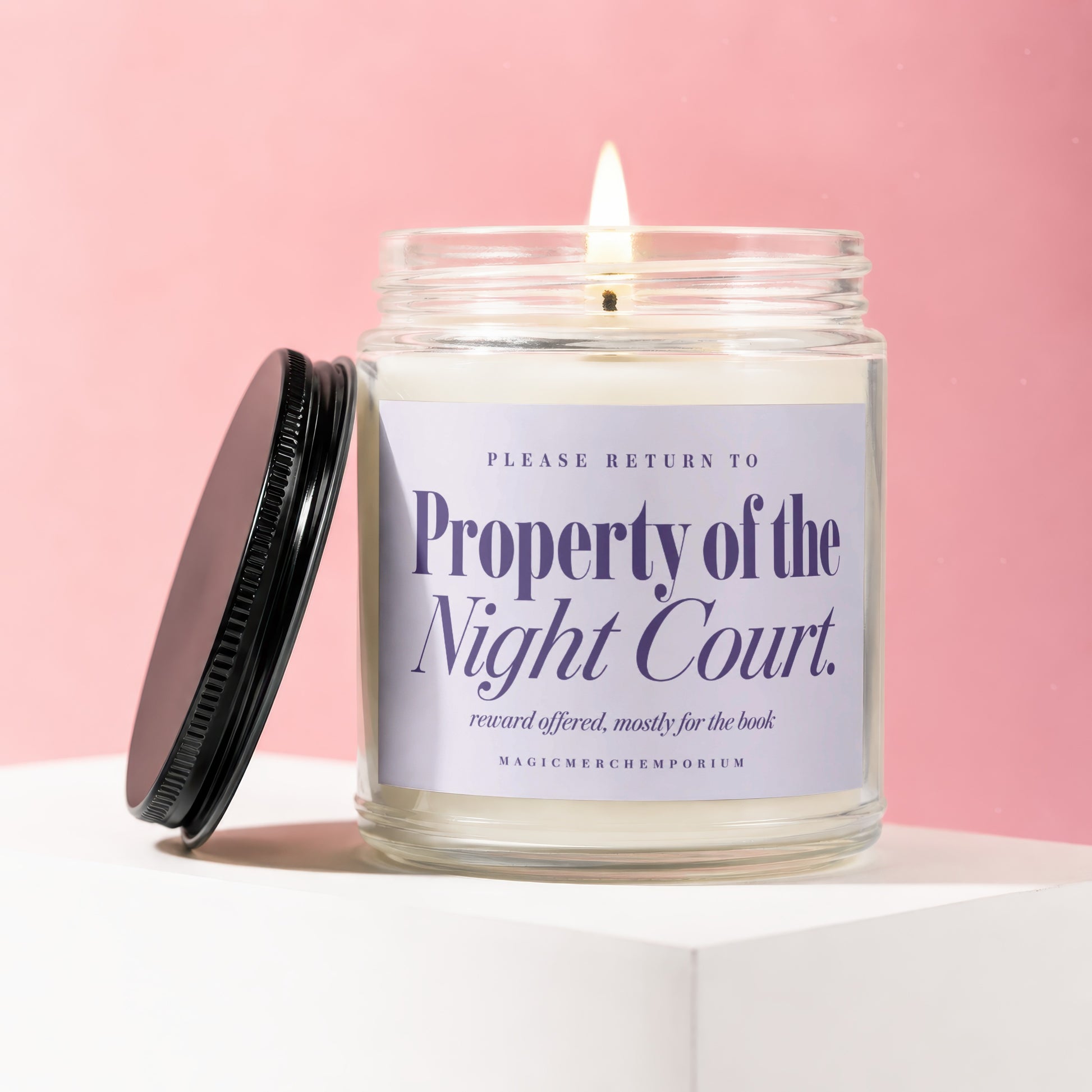 Jar candle with a lit wick and lavender label reading "Property of the Night Court."