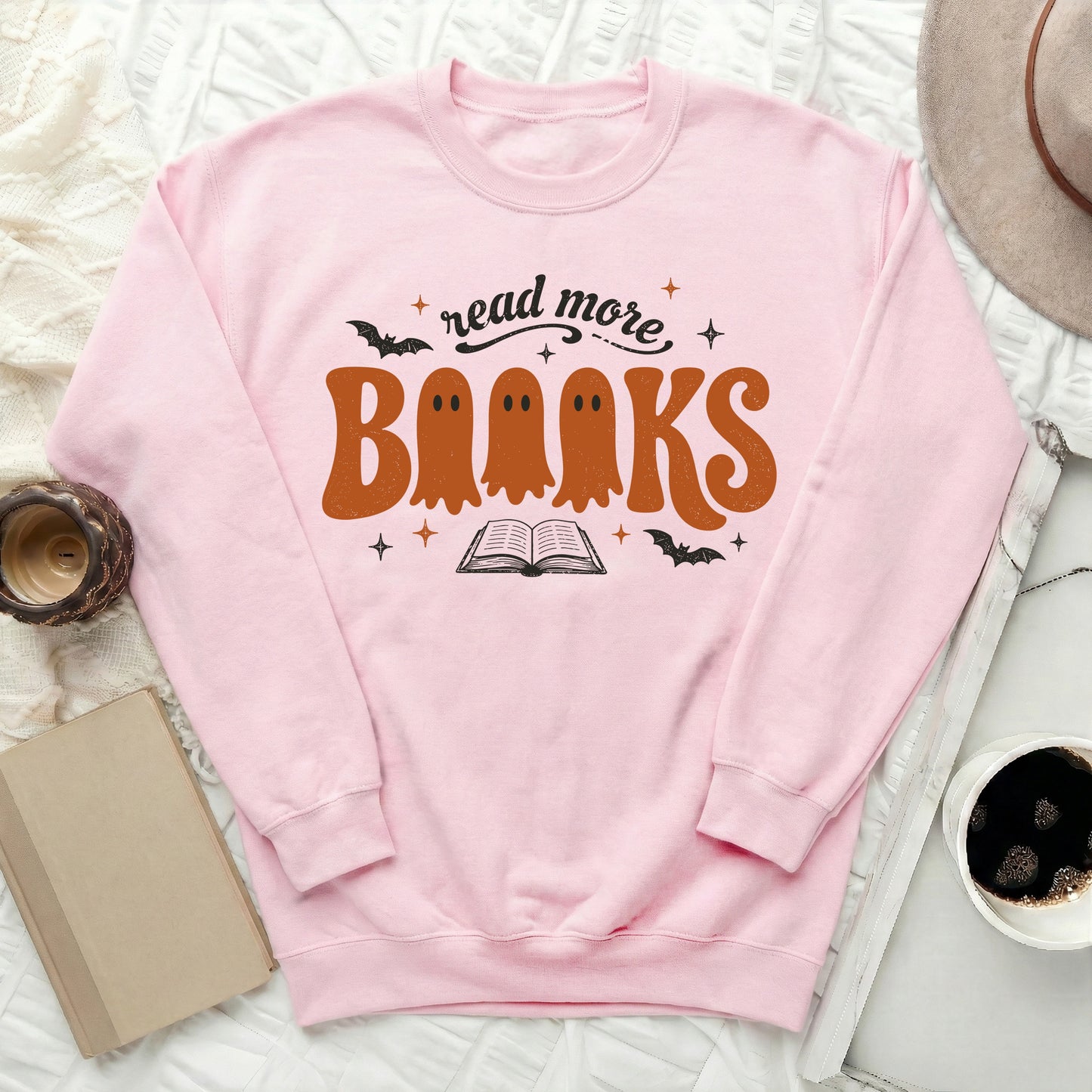 Pink sweatshirt with "read more books" text and ghost graphics.