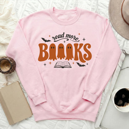 Pink sweatshirt with "read more books" text and ghost graphics.