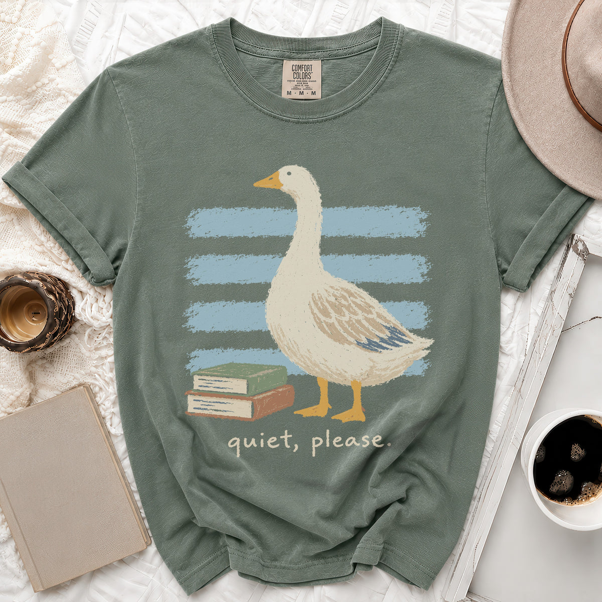 Green t-shirt with a goose, books, and "quiet, please" text.