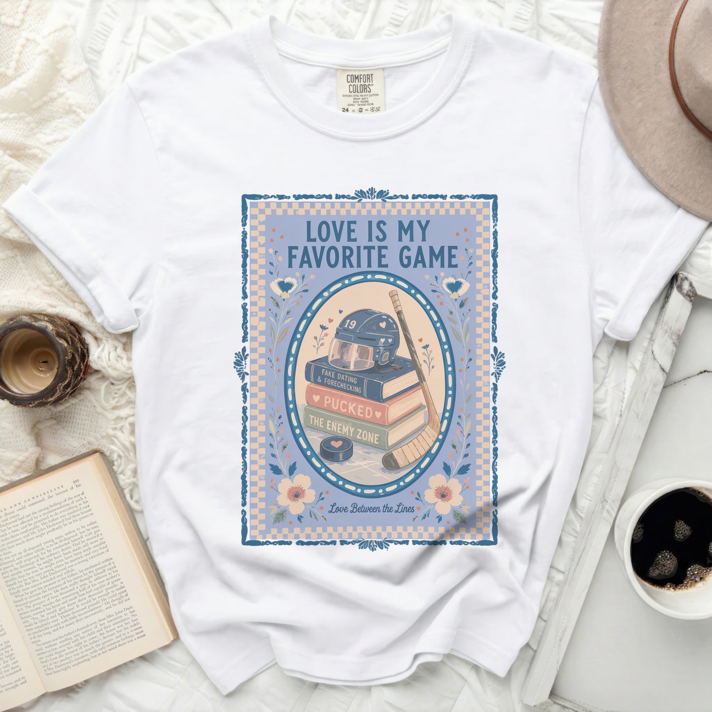 White Comfort Colors t-shirt with "Love Is My Favorite Game" text and hockey graphics.