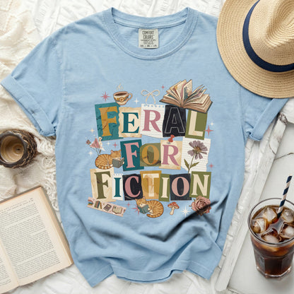 Light blue t-shirt with "Feral for Fiction" text and book graphics.