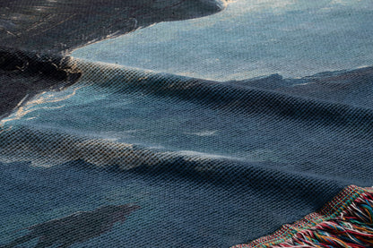 a close-up view of a textured fabric with a blue and black color scheme, featuring a pattern resembling waves or water.