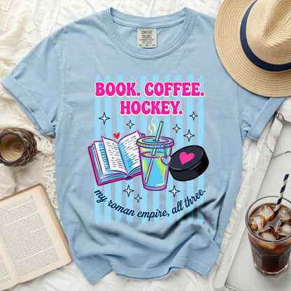 Blue t-shirt with "BOOK. COFFEE. HOCKEY." and "my roman empire, all three." text.