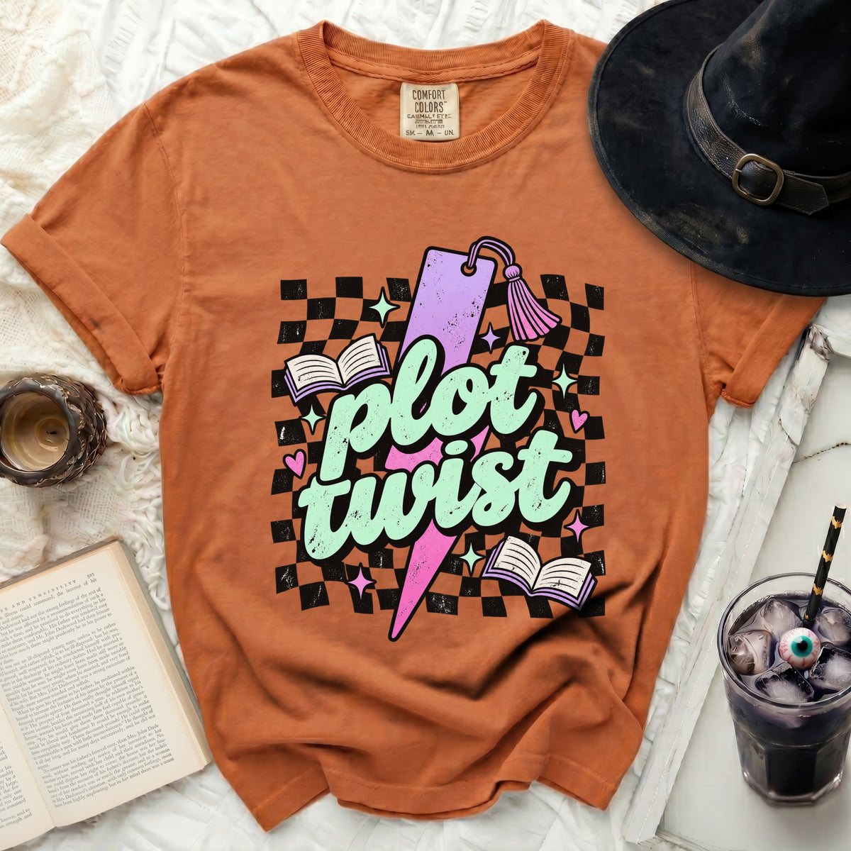 Orange Comfort Colors t-shirt with "plot twist" graphic and witch hat.