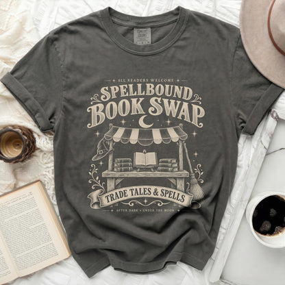 Spellbound Book Swap graphic tee with books, witch hat, and broom.