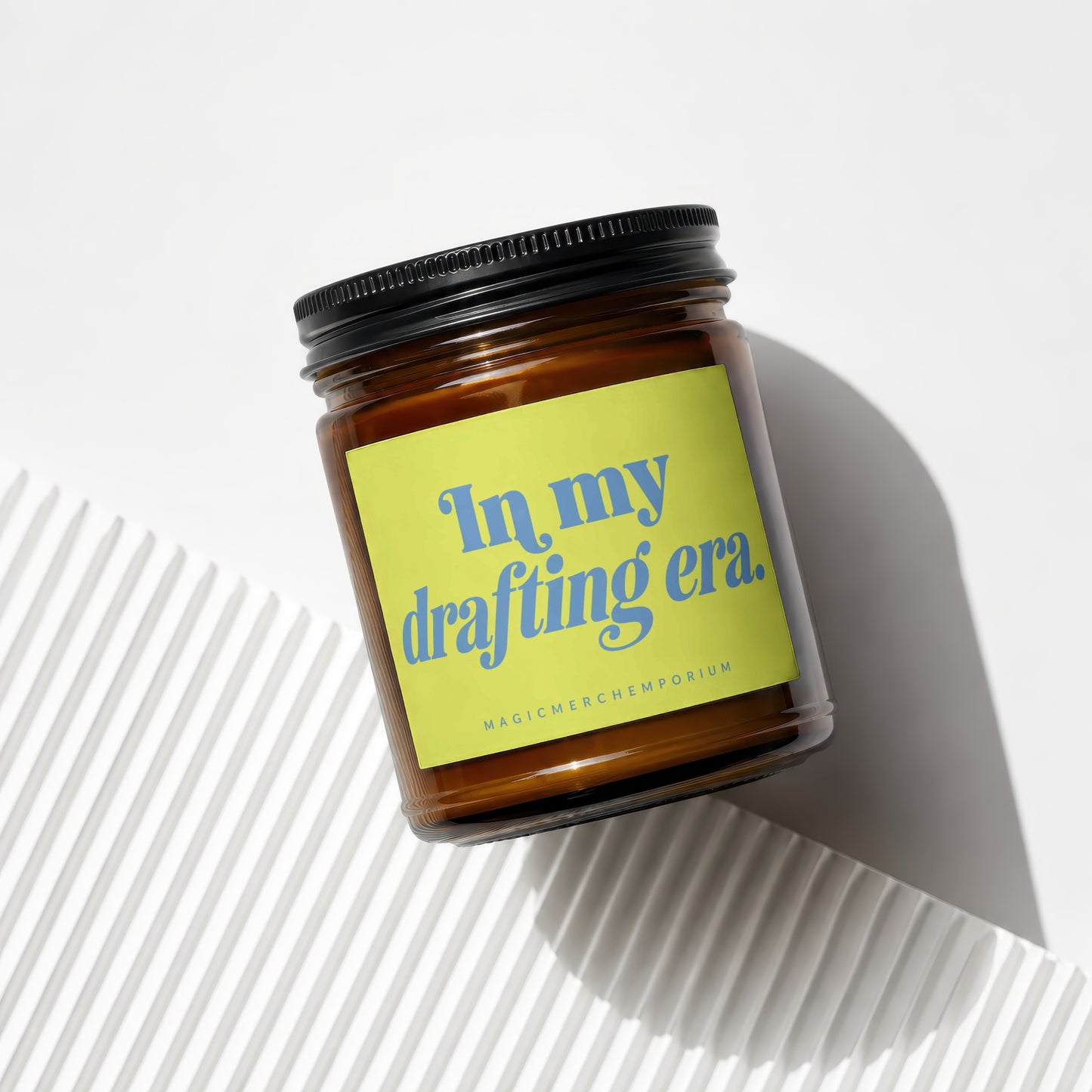 Brown glass candle with "In my drafting era." text on a lime green label.