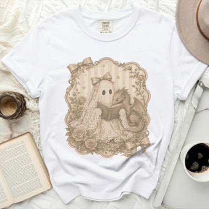 White t-shirt with a lace ghost and dragon reading a book graphic.