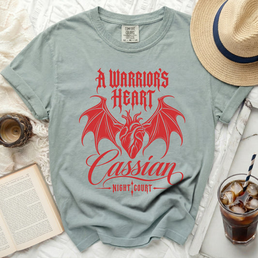 Light blue t-shirt with red "A Warrior's Heart" text and bat wings.