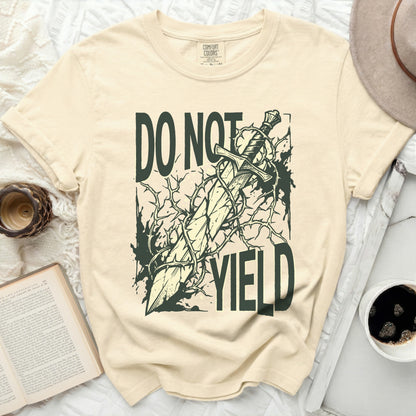 Cream t-shirt with a graphic of a sword entangled in thorns, text "DO NOT YIELD".