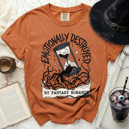 Orange t-shirt with "Emotionally Destroyed by Fantasy Romance" hourglass graphic.