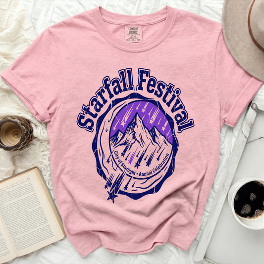 Pink t-shirt with a circular graphic featuring mountains, stars, and text.