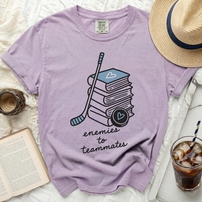 T-shirt with hockey stick, puck, and books graphic, "enemies to teammates" text.