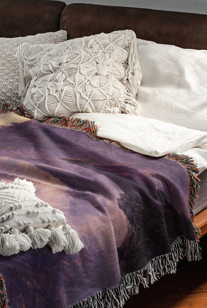 a cozy and inviting bedroom scene, featuring a bed with a purple blanket and white pillows, as well as a brown leather couch.
