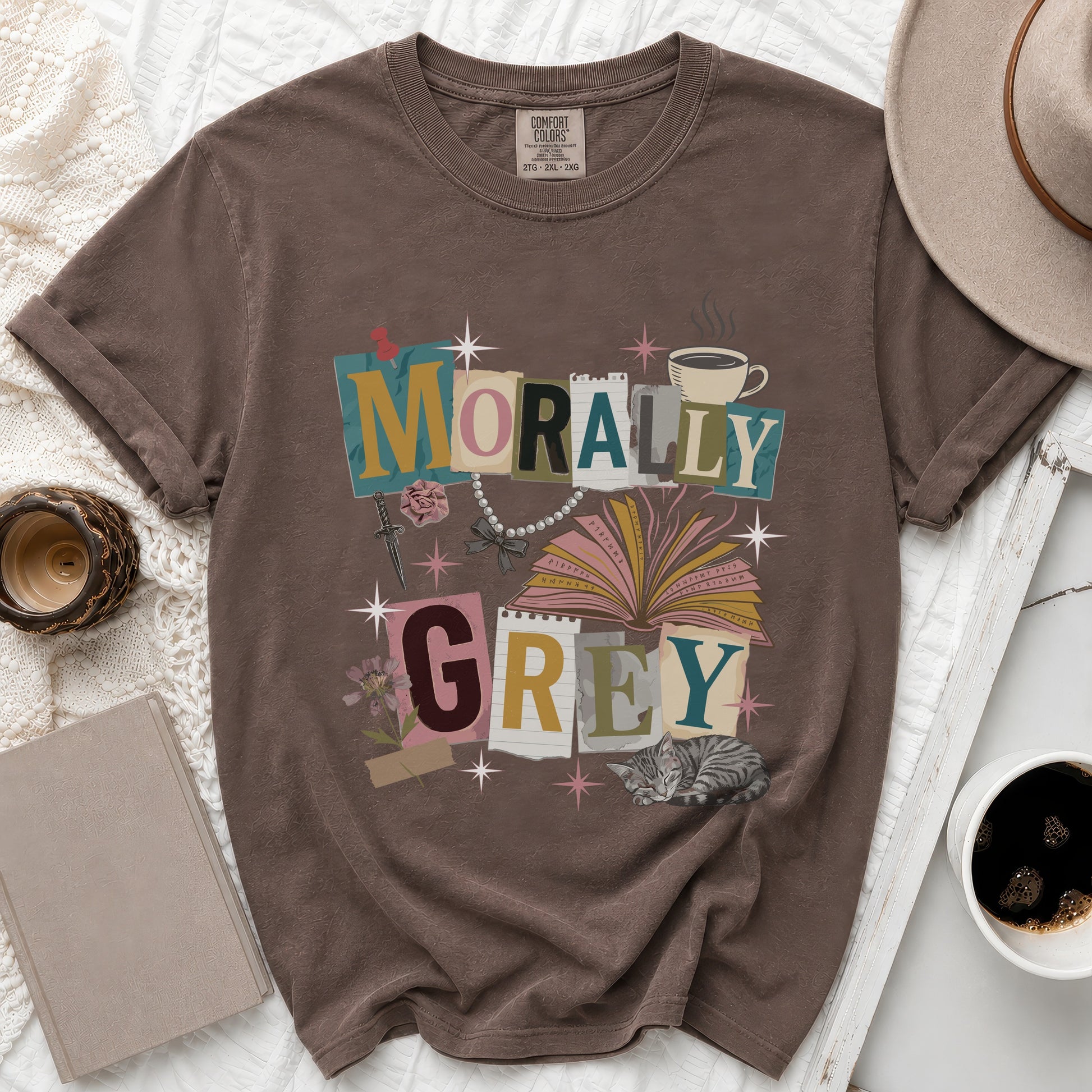 Brown t-shirt with "MORALLY GREY" text, open book, and sleeping cat graphic.