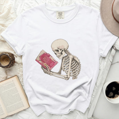 Skeleton reading a pink book titled "Once Upon a Broken Heart"