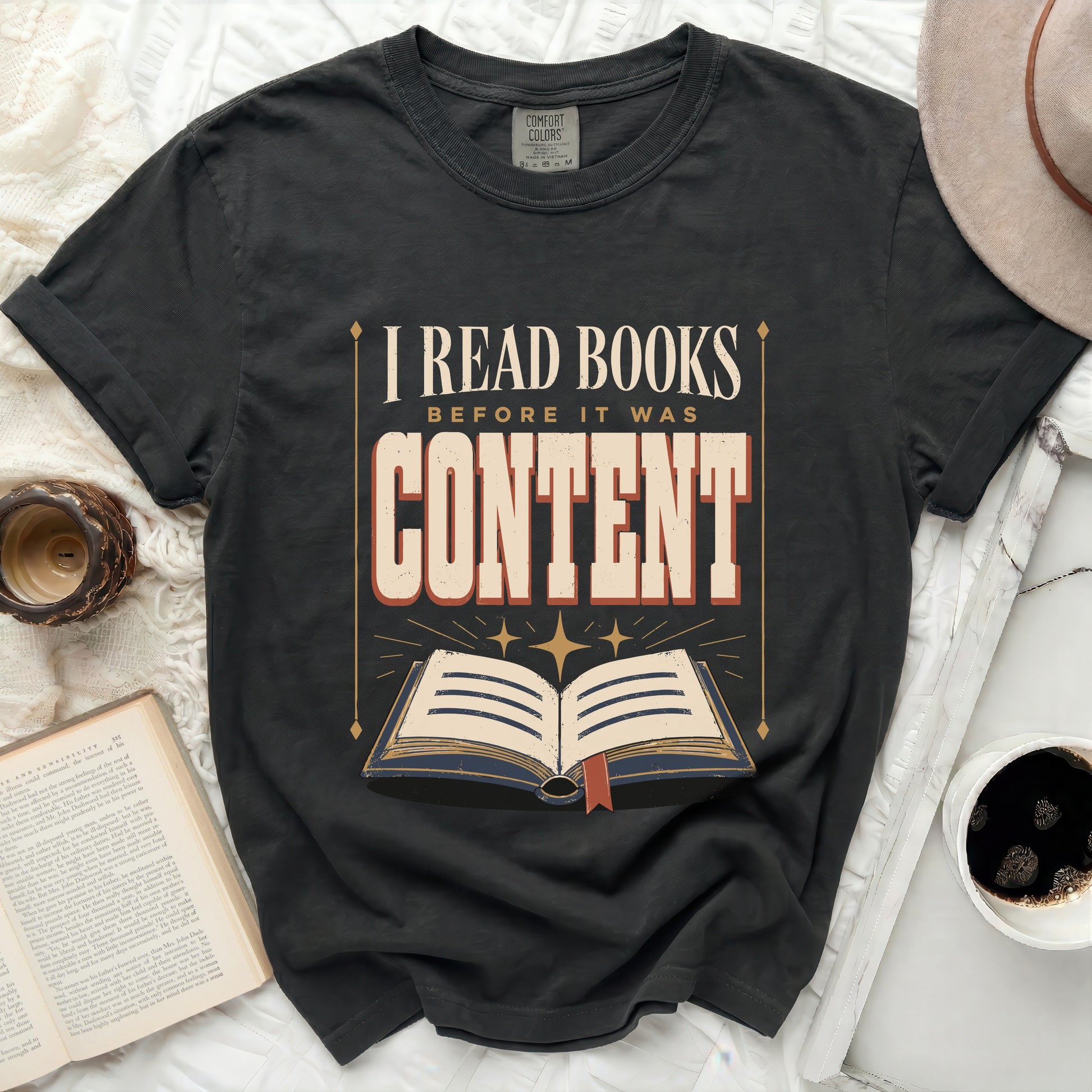 Dark t-shirt with "I READ BOOKS BEFORE IT WAS CONTENT" graphic and open book.